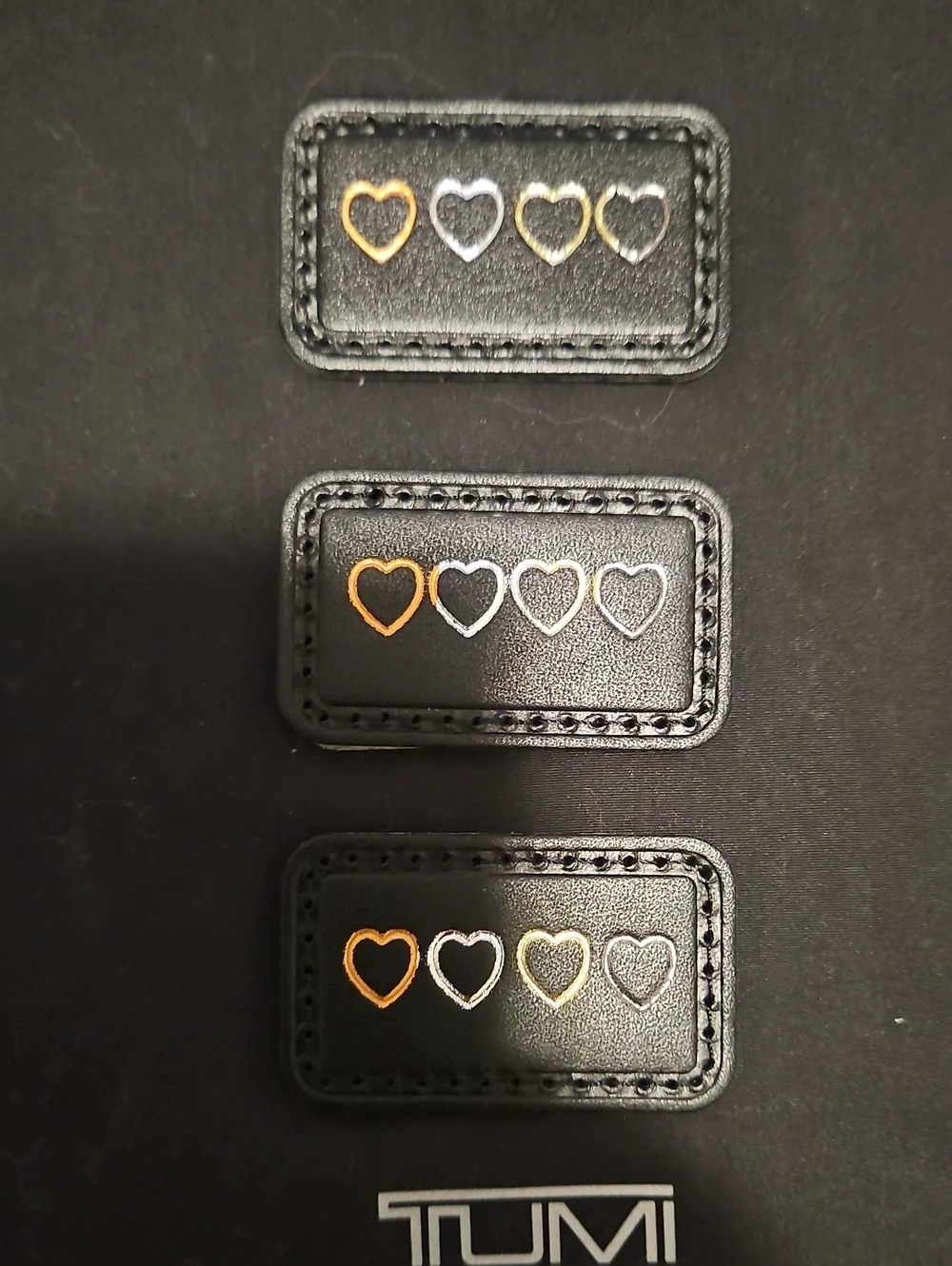 Tumi Black Leather Patches with Gold & Silver Heart Accents.  $10 Each